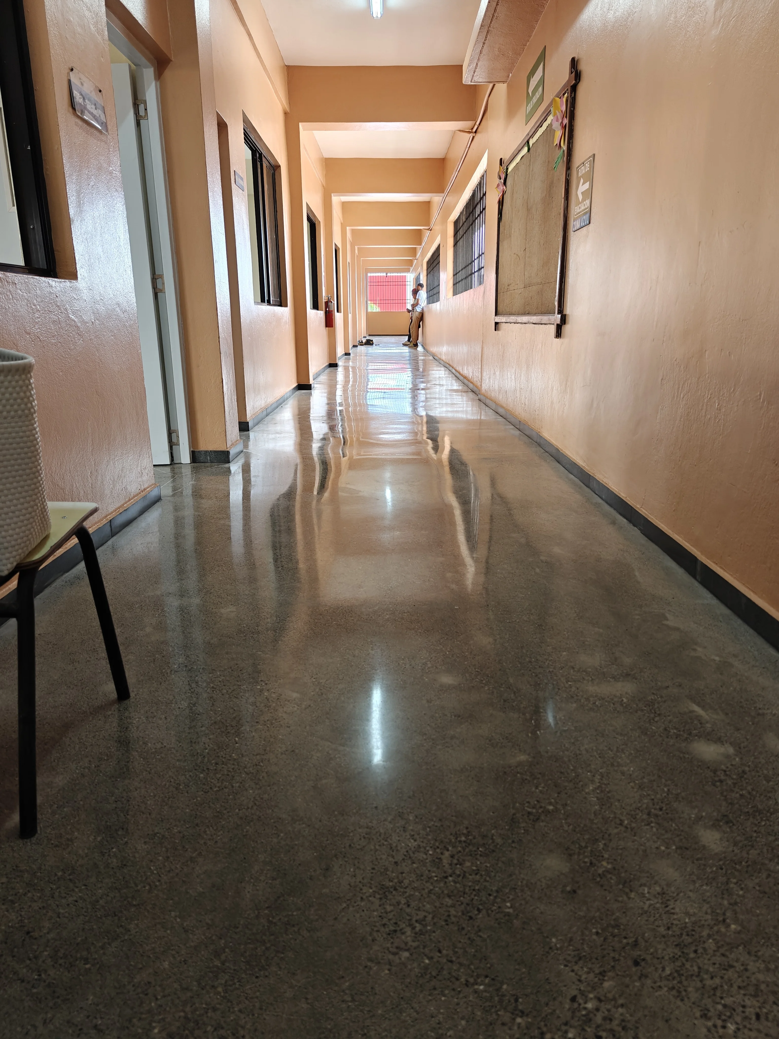BrightConcrete™ — La superficie pulida refleja la luz natural a lo largo del corredor, aportando amplitud y luminosidad al espacio.