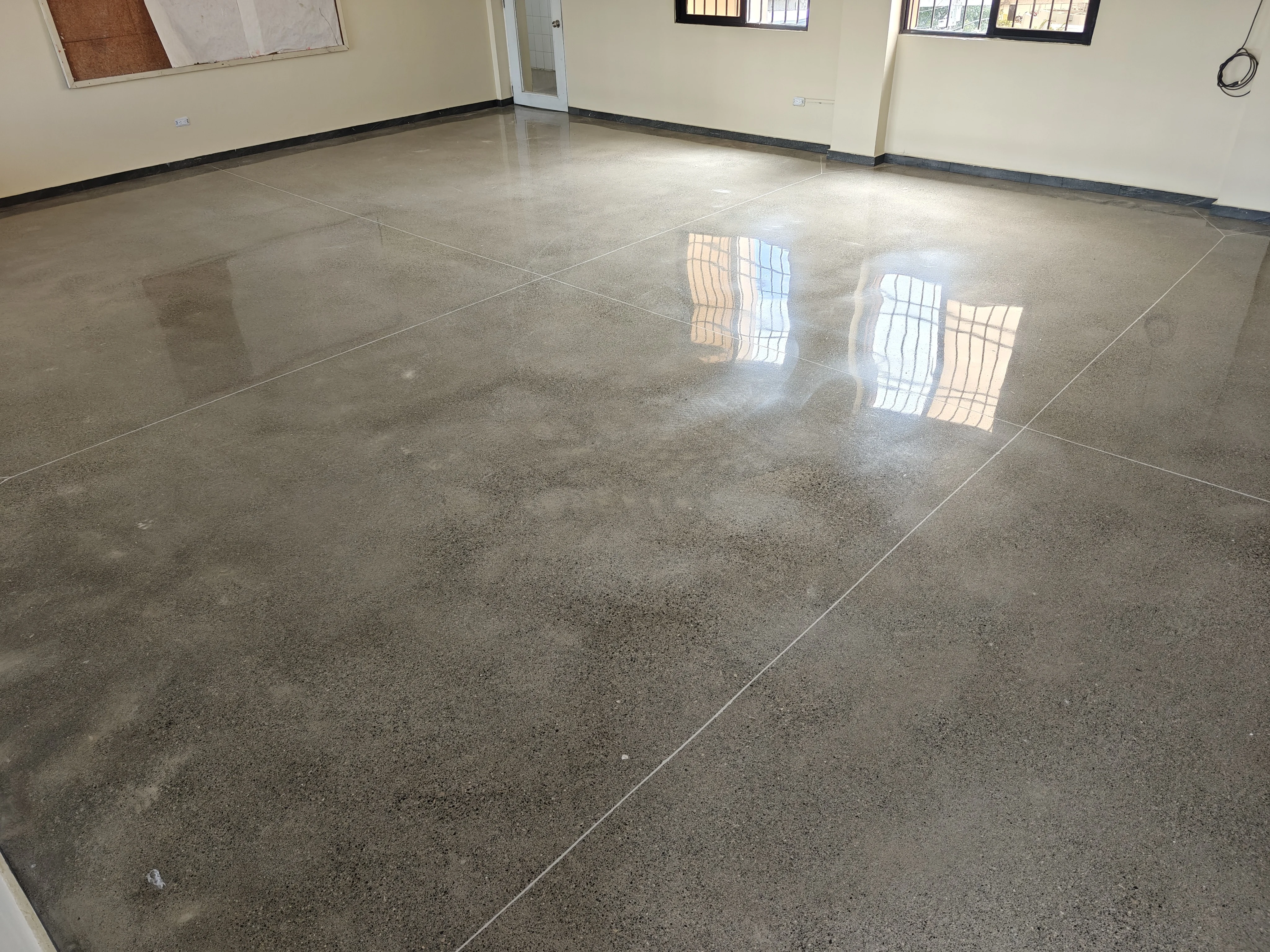 BrightConcrete™ — El reflejo claro de las ventanas sobre el piso evidencia el alto nivel de pulido alcanzado en la obra.