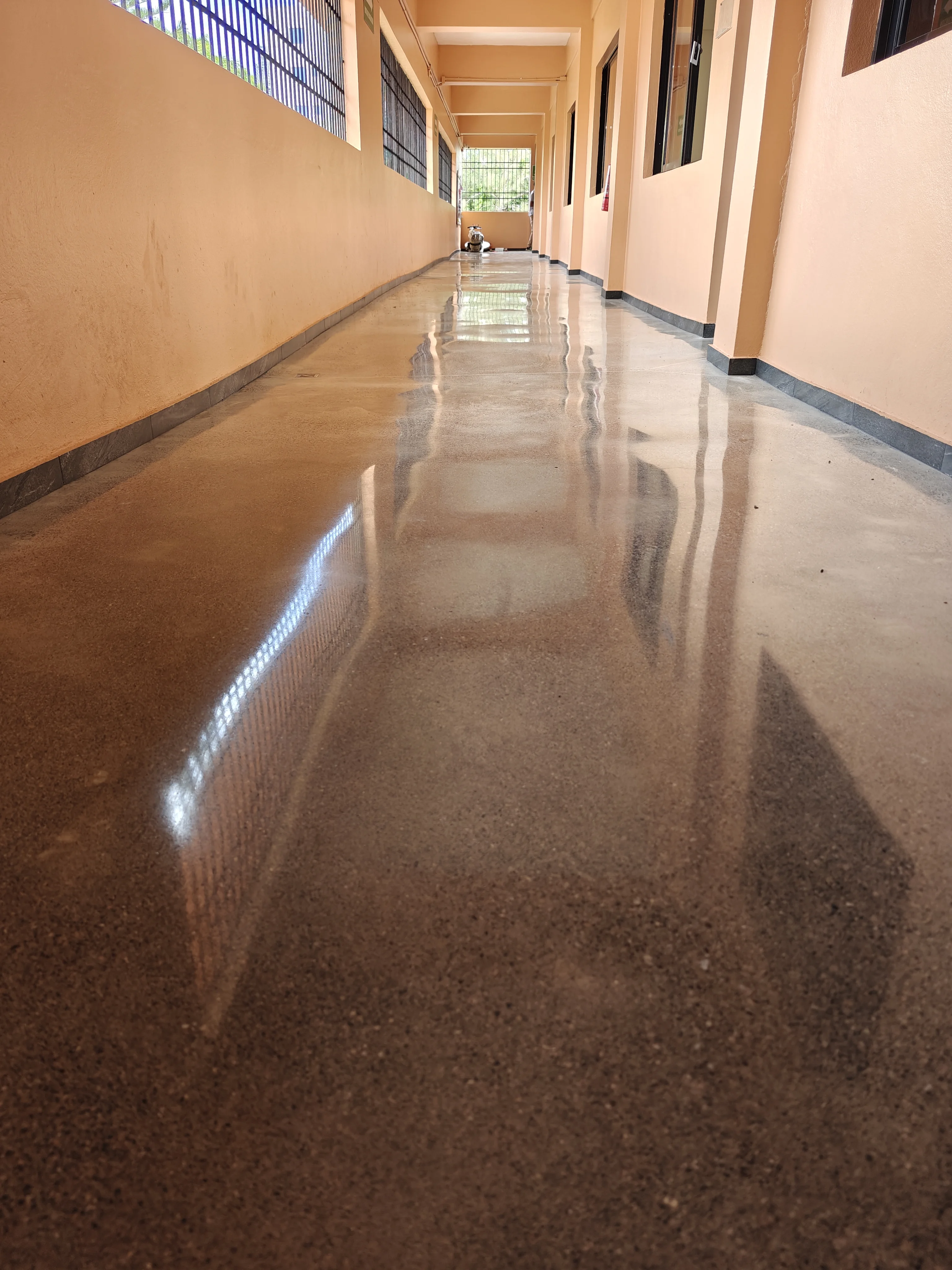 BrightConcrete™ — El pulido tipo espejo multiplica la iluminación del pasillo y reduce la dependencia de luz artificial.